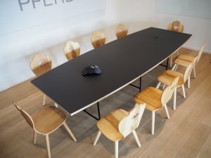 Moderner Meetingraum schwarzer Tisch mit modernen Holzstühlen im Alpenstyle