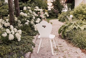 weißer SÜSSHOLZ Herzerlstuhl neben weißen Hortensien