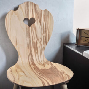 Bauernstuhl aus Kernesche in moderner Form vor Betonwand